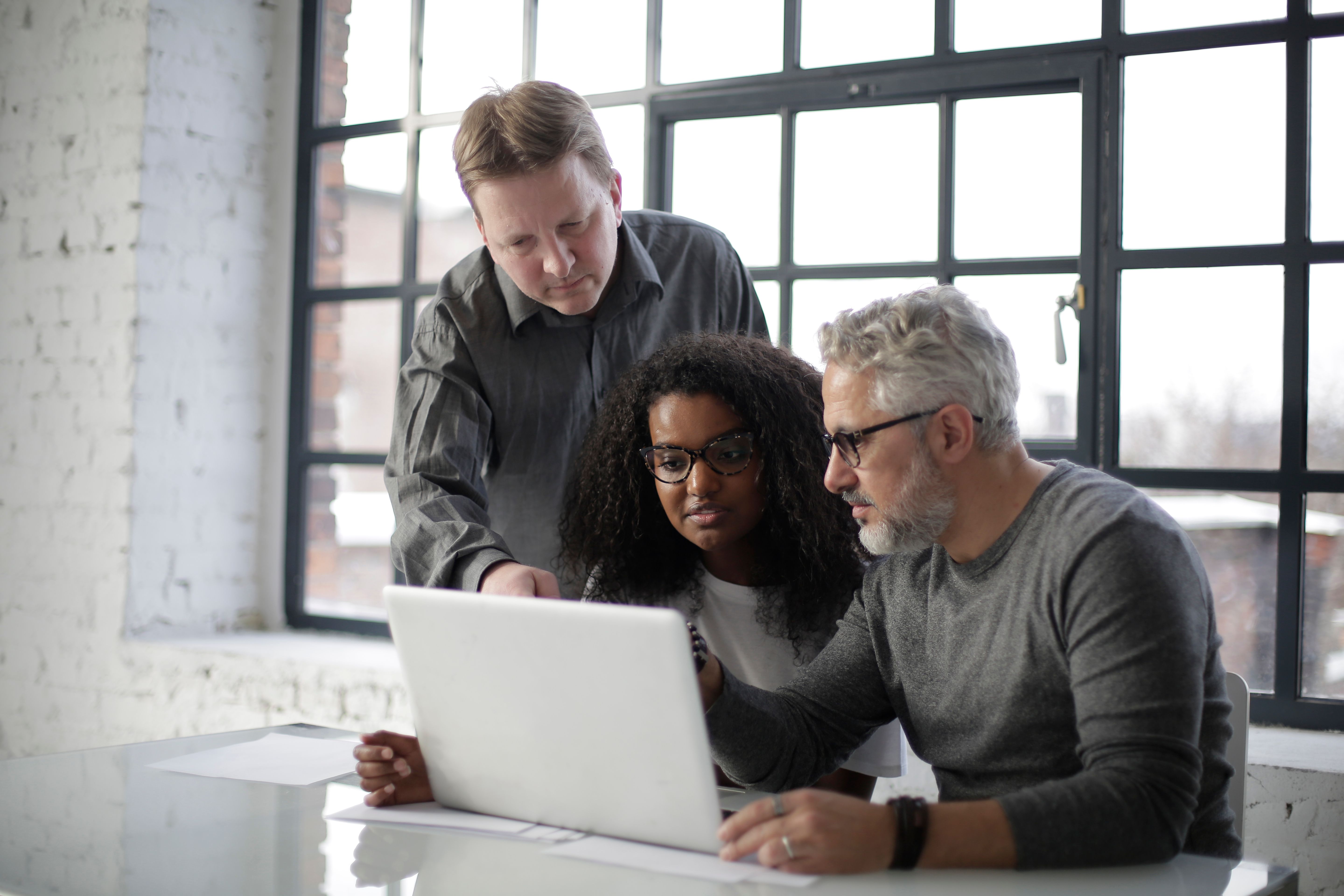 Business team reviewing a workflow on a laptop