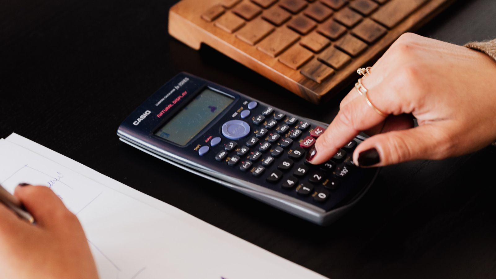 Person calculating business costs at a desk