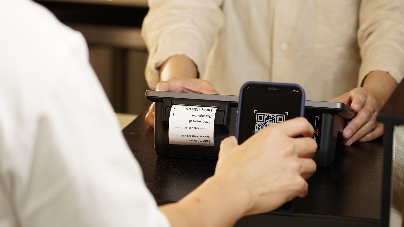 Pharmacy assistant scanning a prescription token from a patient's phone at the counter