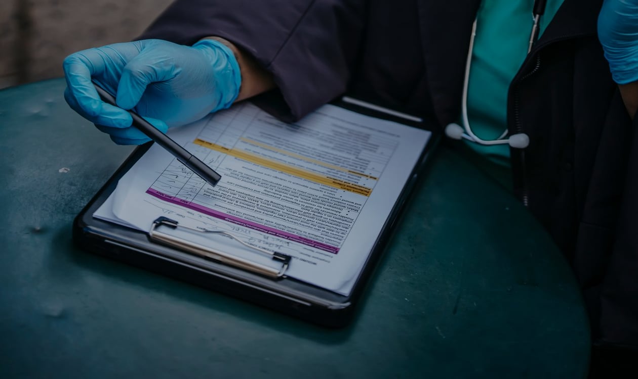 Healthcare professional reviewing paperwork at a desk