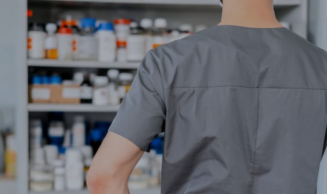 Pharmacist organising medicine shelves as part of a pharmacy workflow