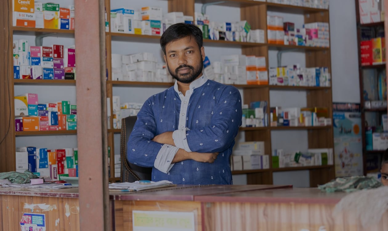 Pharmacist serving a customer at a community pharmacy counter