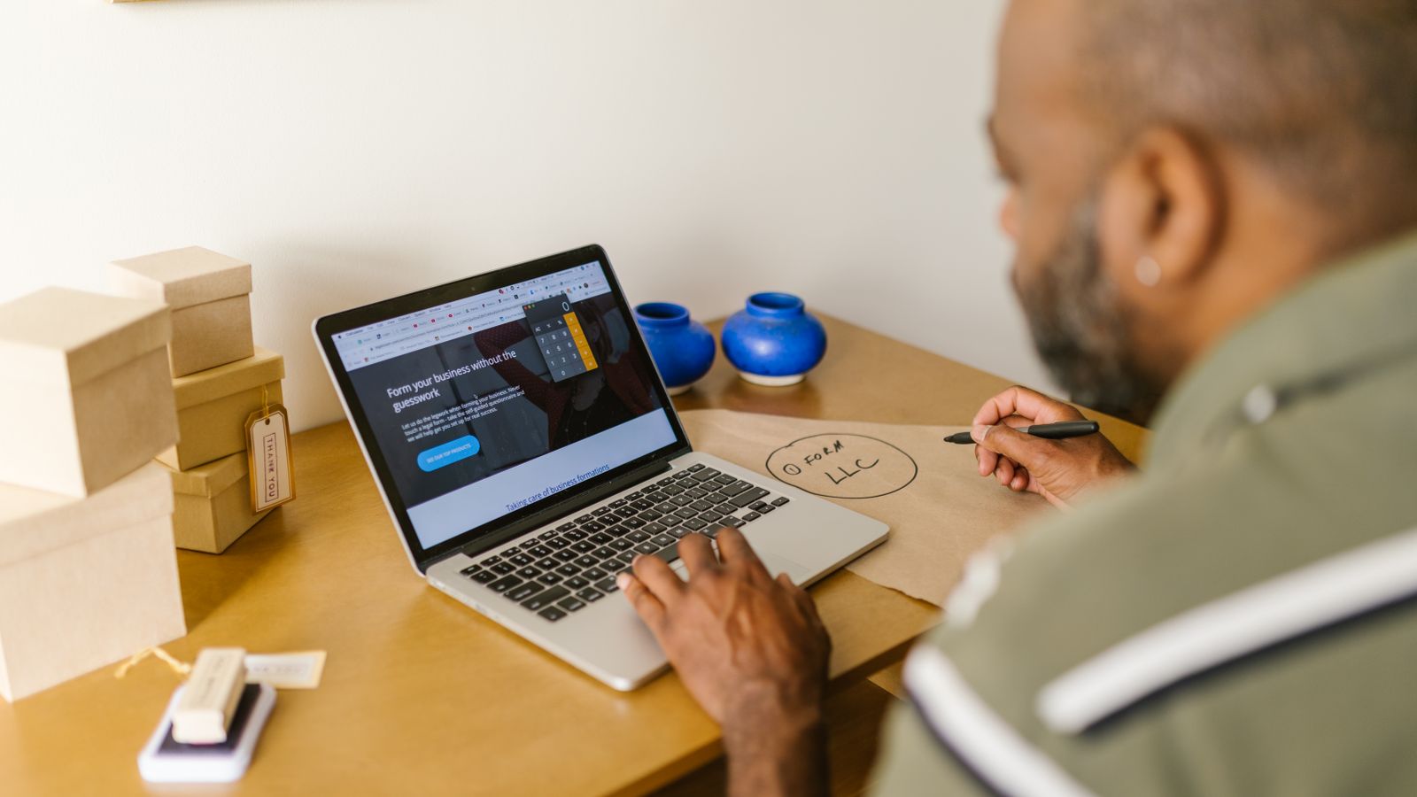 A small business owner working at a laptop